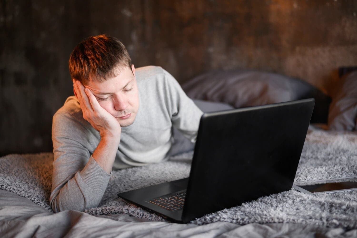 Homme qui s'endort devant son ordinateur portable